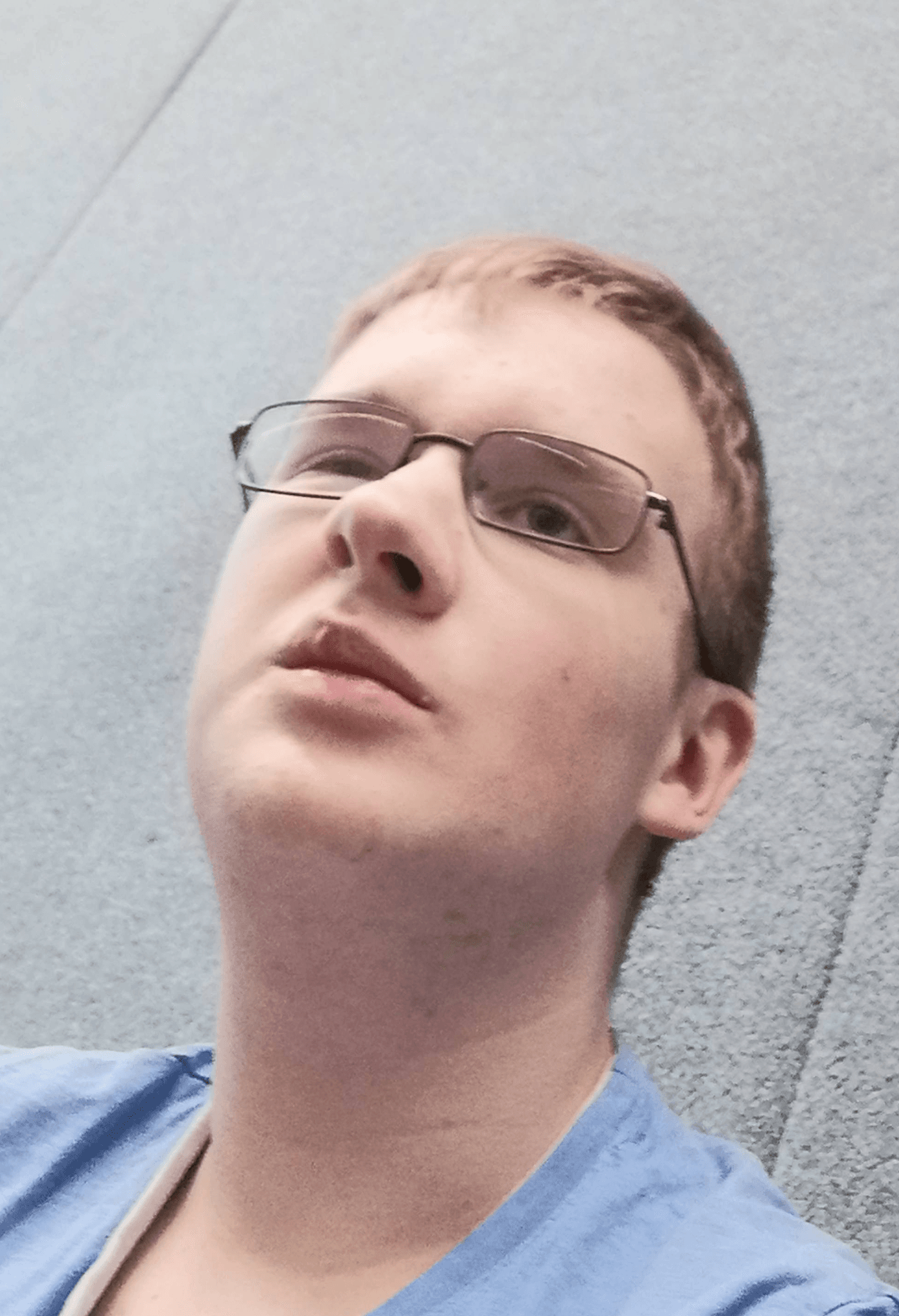 young man wearing glasses and blue shirt