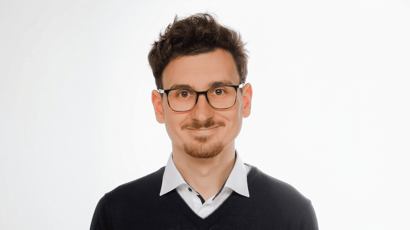 Young man with glasses and dark curly hair